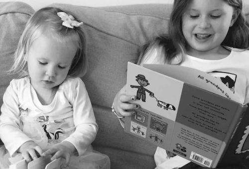 Two little girls reading books