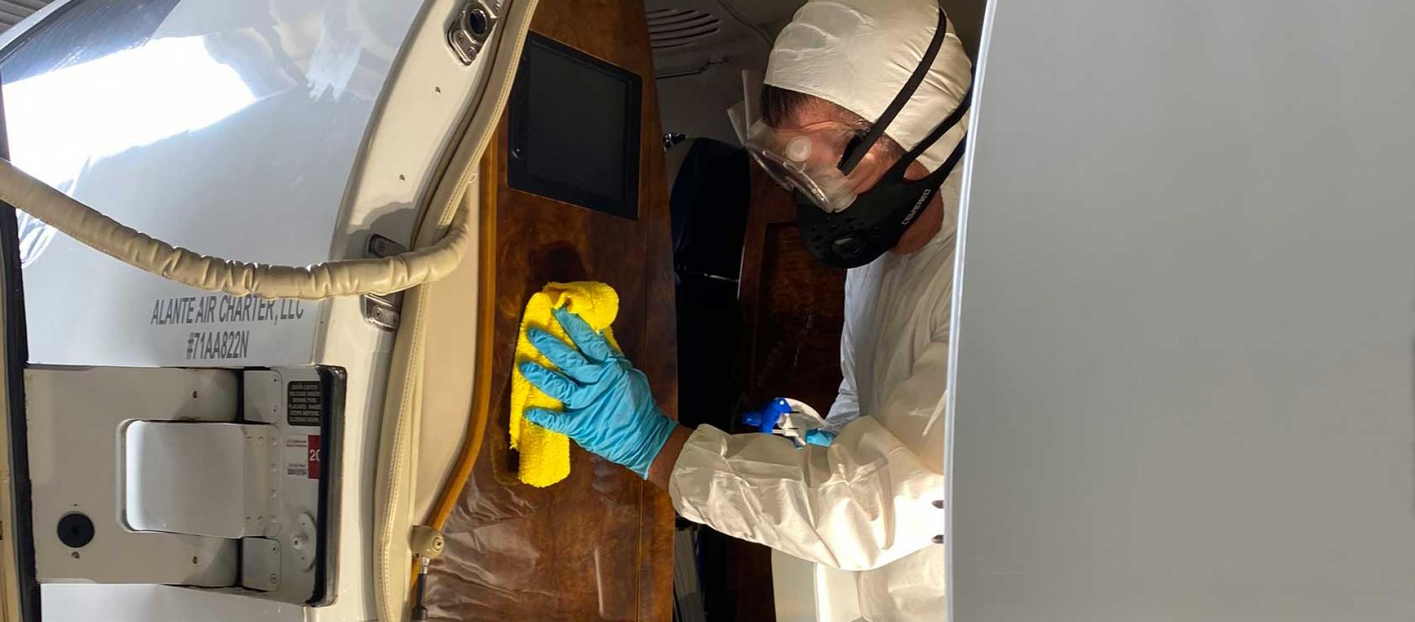 Worker disinfecting aircraft