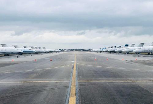 Private jets line a runway used for overflow parking at Miami Opa-locka Executive Airport