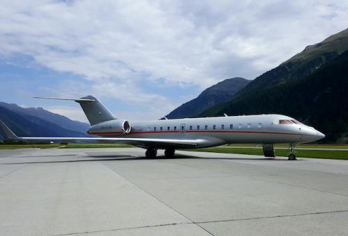 VistaJet Global 6000 on the ramp surrounded by mountainous terrain