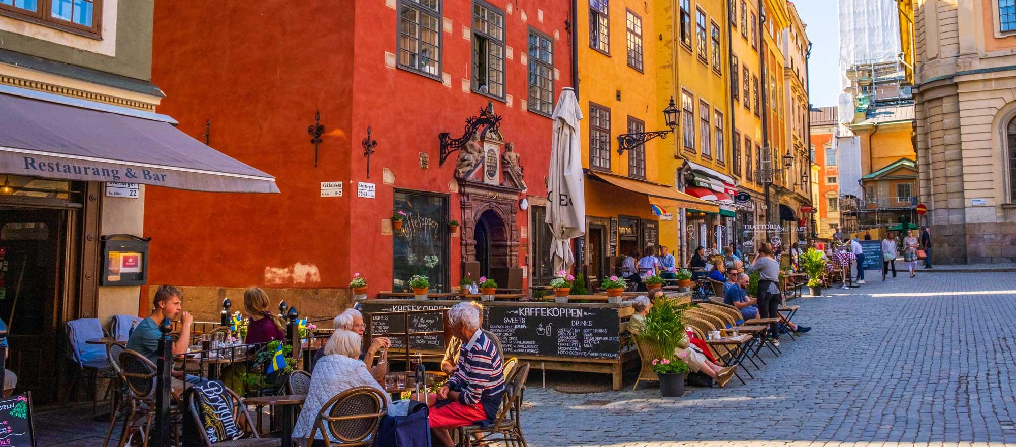 Stockholm Sweden - July 1 2021: Colourful historic buildings and houses in Gamla Stan, Main S. Romantic medieval city centre alleys. Photo: Adobe Stock