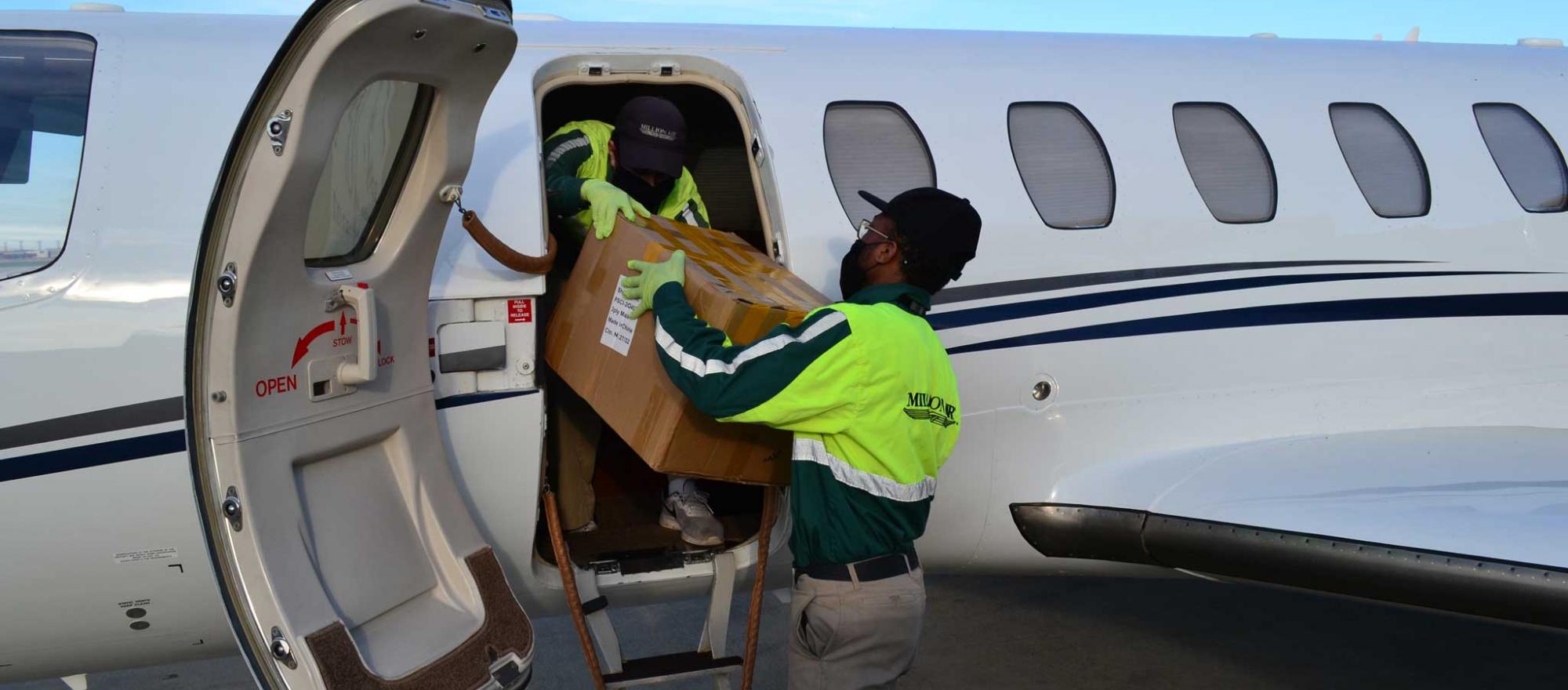 Loading donated boxes of masks aboard business jet