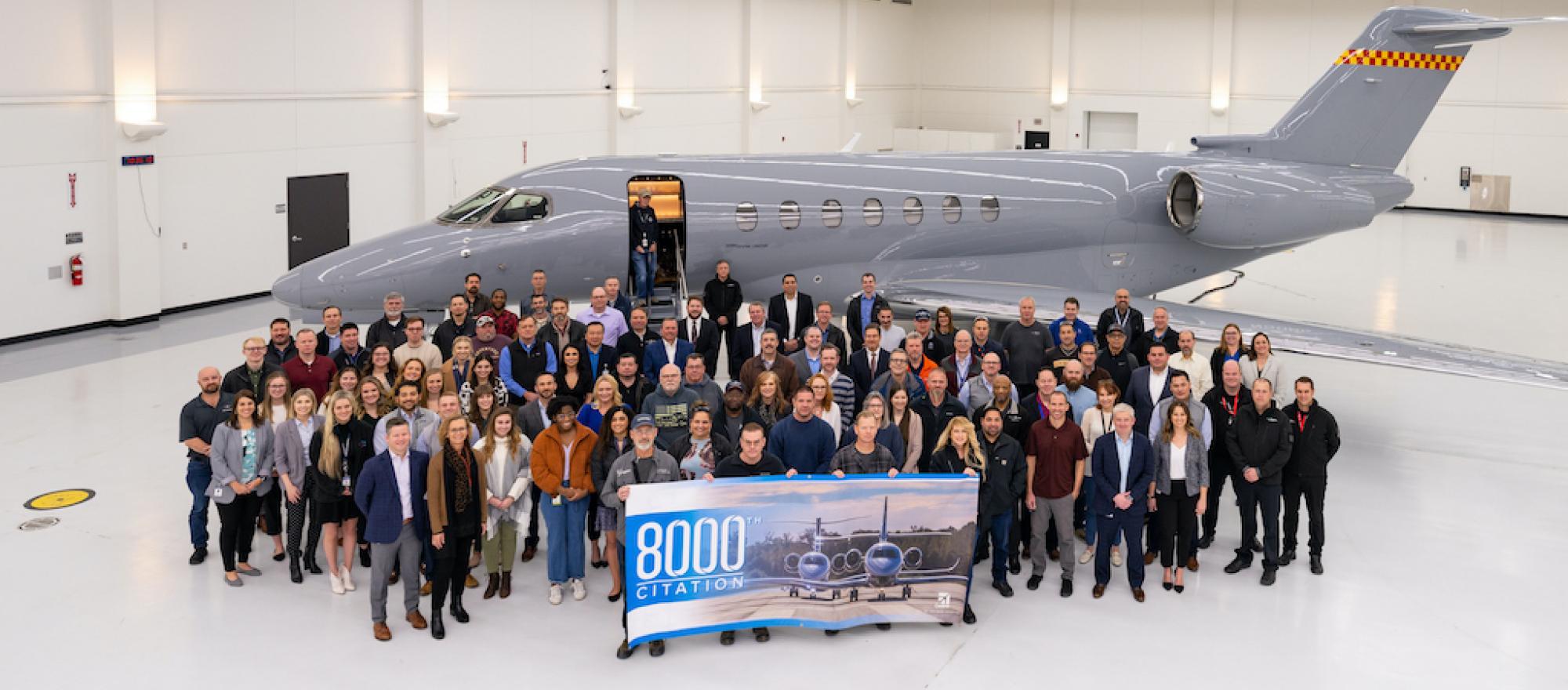 Textron Aviation employees and Scotts Miracle-Gro representatives gather in front of a Cessna Citation Longitude with banner celebrating the 8,000th Citation delivery.