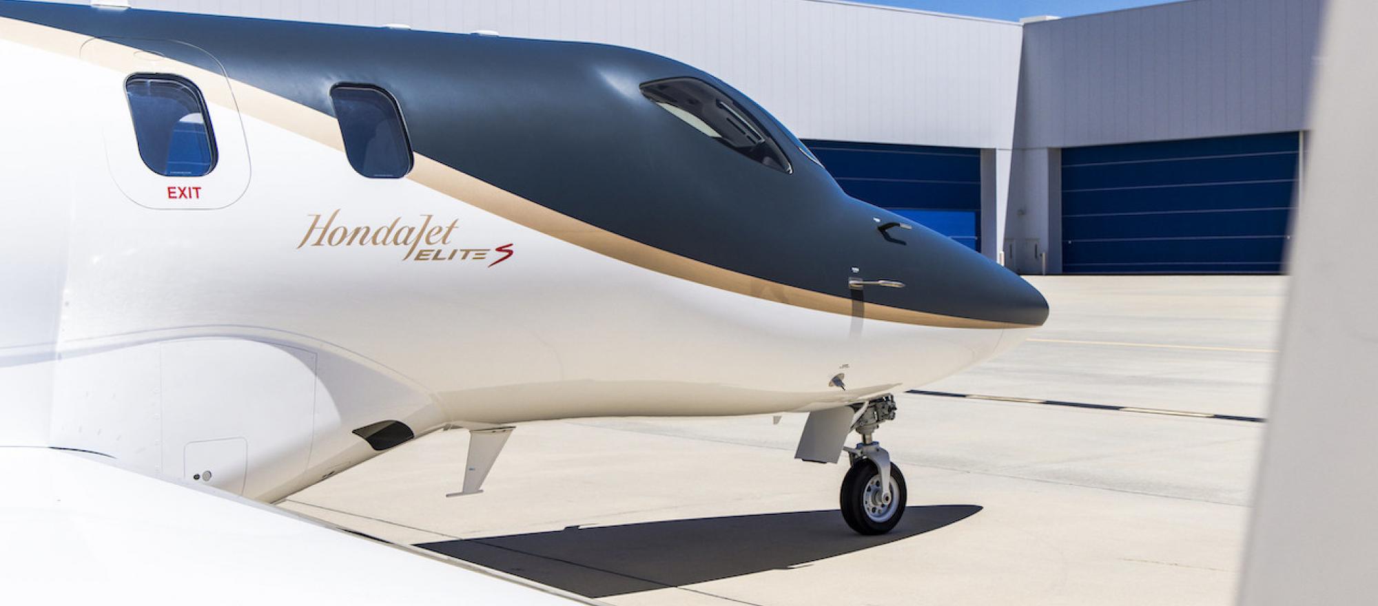 image of front half of HondaJet Elite parked on ramp outside of hangars 